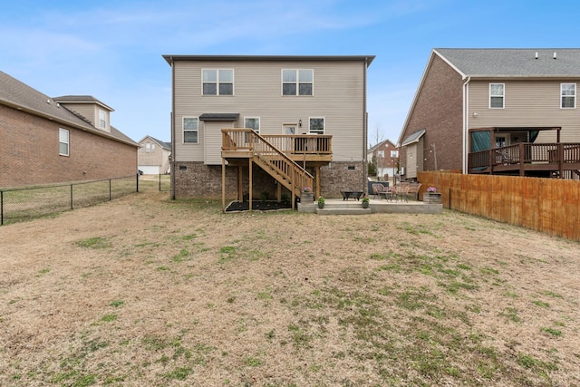 rear view of property featuring a lawn, a patio, a fenced backyard, a wooden deck, and stairs