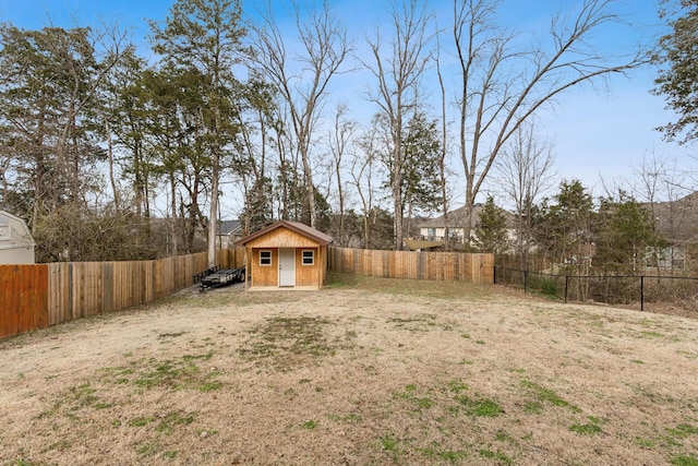 view of yard featuring a fenced backyard, an outbuilding, and a storage shed