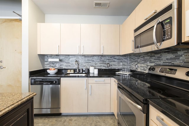 kitchen with decorative backsplash, visible vents, appliances with stainless steel finishes, and a sink