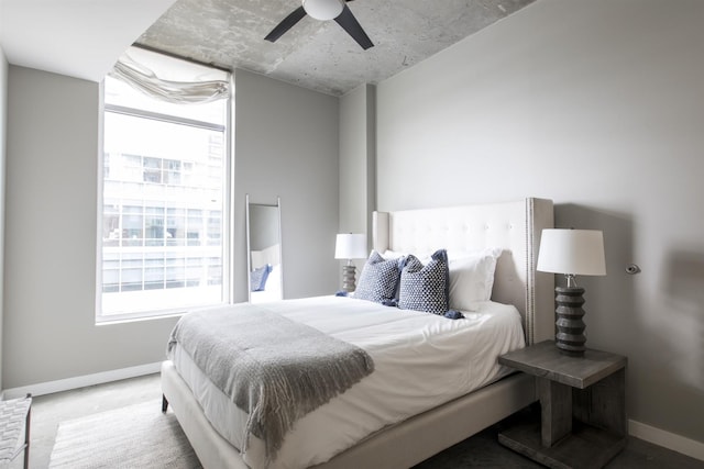 bedroom with multiple windows, a ceiling fan, and baseboards