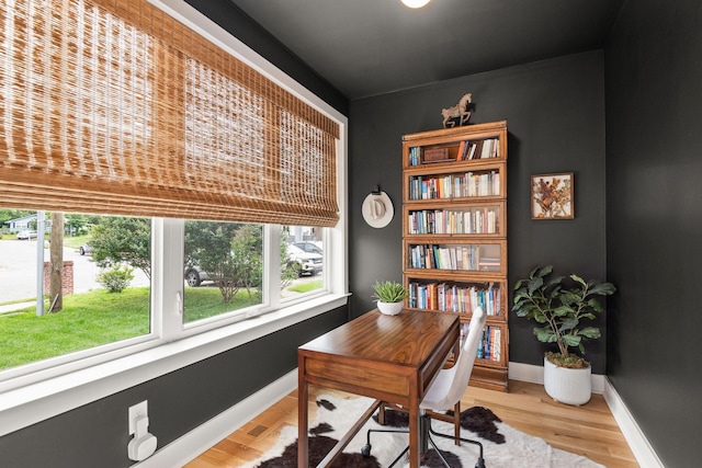 office space featuring baseboards and light wood finished floors