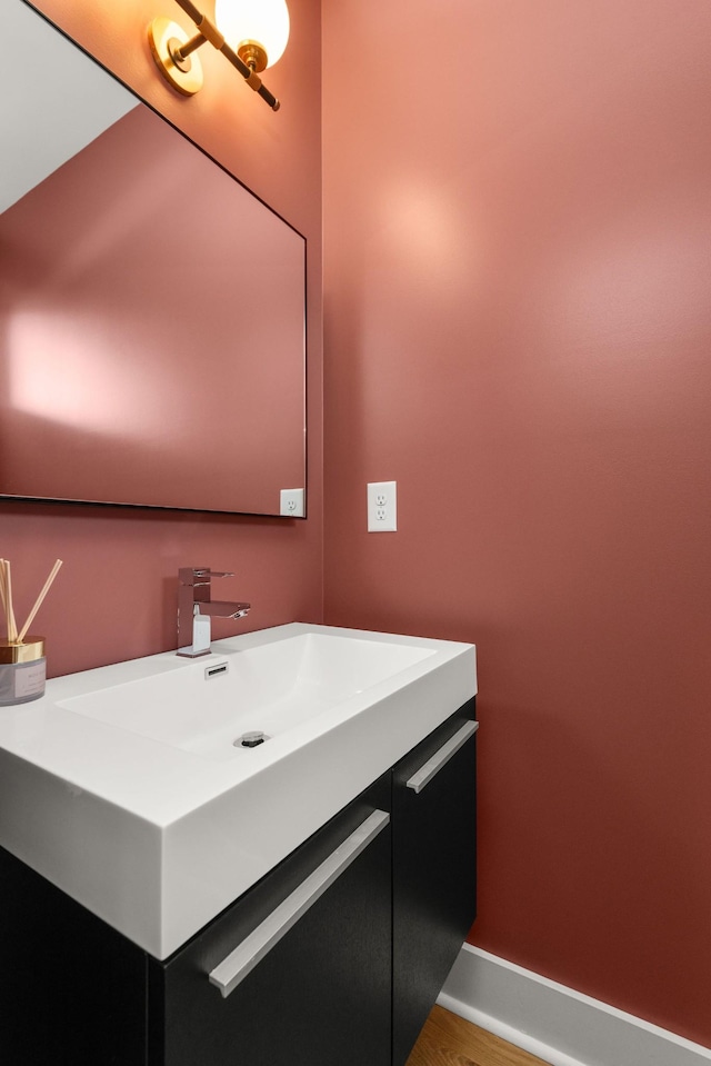 bathroom featuring vanity, wood finished floors, and baseboards