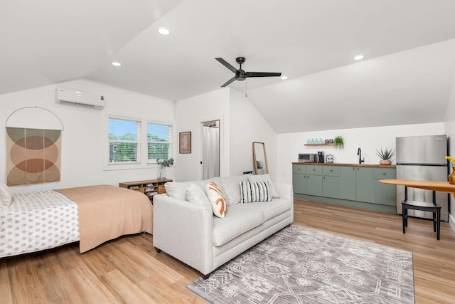 bedroom featuring an AC wall unit, light wood-type flooring, vaulted ceiling, recessed lighting, and freestanding refrigerator