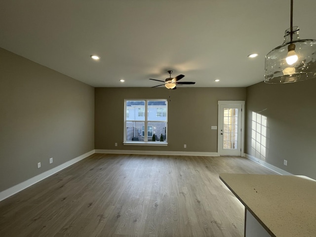 unfurnished living room featuring recessed lighting, a ceiling fan, baseboards, and wood finished floors