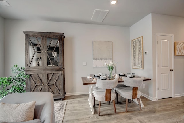 dining room featuring baseboards, visible vents, and light wood-type flooring