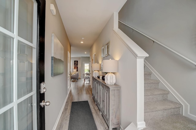 hall featuring stairs, recessed lighting, baseboards, and light wood finished floors