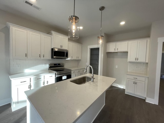 kitchen with visible vents, dark wood-style flooring, a sink, stainless steel appliances, and white cabinetry