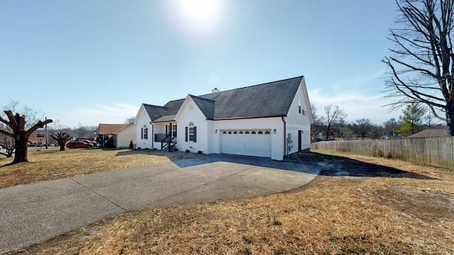 view of front facade featuring concrete driveway and fence