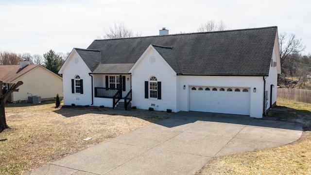 view of front of property with driveway, central AC, a chimney, a garage, and brick siding