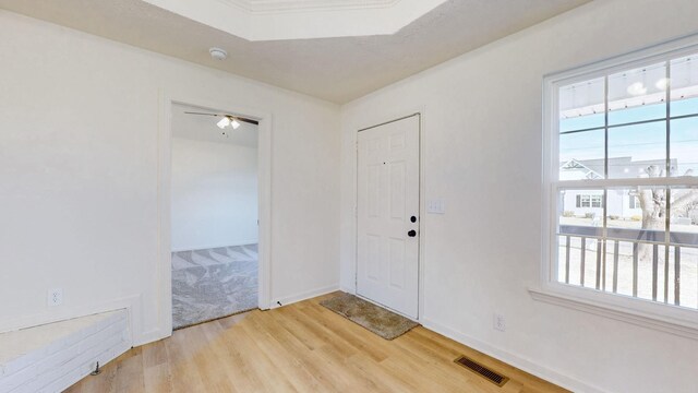 foyer entrance with light wood-style floors, visible vents, and baseboards