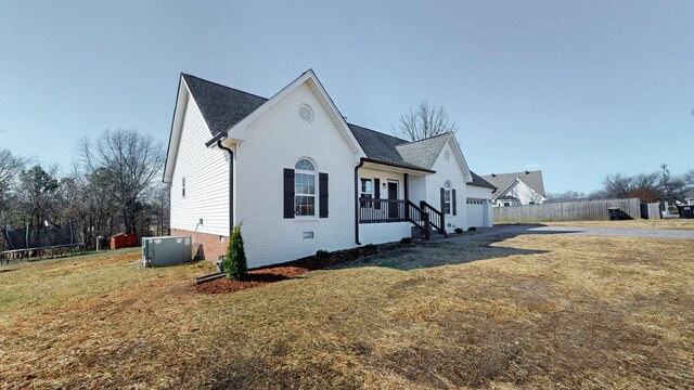 view of front of home with a front yard, central AC unit, crawl space, a trampoline, and brick siding