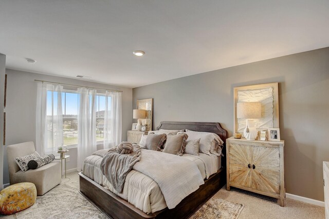 bedroom with visible vents, light colored carpet, and baseboards