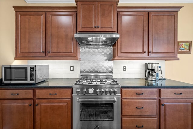 kitchen with ventilation hood, dark stone counters, decorative backsplash, brown cabinets, and appliances with stainless steel finishes