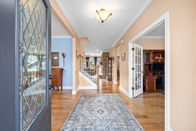 foyer with french doors, wood finished floors, crown molding, and stairway