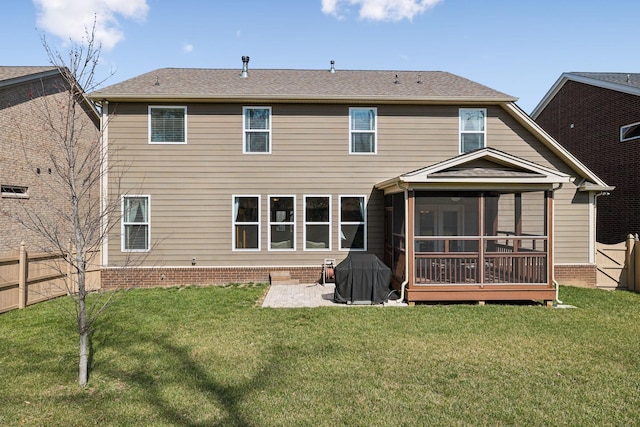 rear view of property with a patio area, a lawn, a fenced backyard, and a sunroom