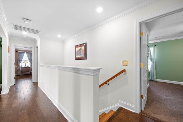 hallway with visible vents, an upstairs landing, wood-type flooring, and ornamental molding