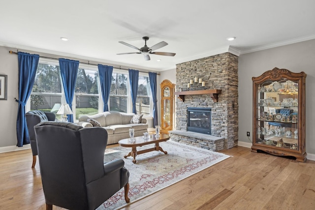 living area with ceiling fan, crown molding, baseboards, and light wood-style floors
