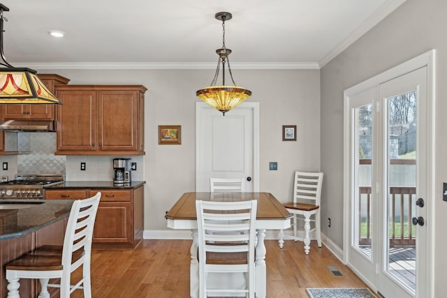 kitchen with visible vents, plenty of natural light, light wood finished floors, and brown cabinetry