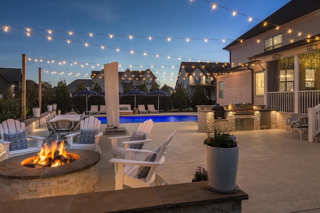 pool featuring a patio area, grilling area, a fire pit, and area for grilling