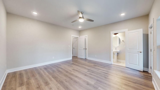 unfurnished bedroom with recessed lighting, baseboards, light wood-type flooring, and connected bathroom