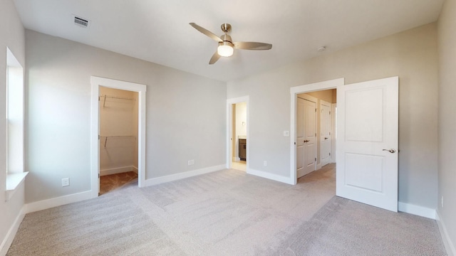 unfurnished bedroom with a spacious closet, baseboards, visible vents, and a closet