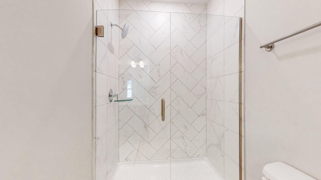 bathroom with a shower stall and toilet