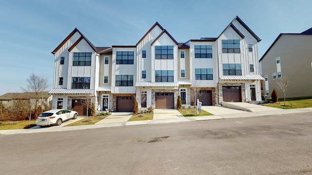 multi unit property with a garage, stone siding, board and batten siding, and driveway