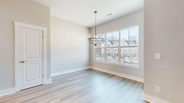 unfurnished dining area with visible vents, baseboards, and wood finished floors