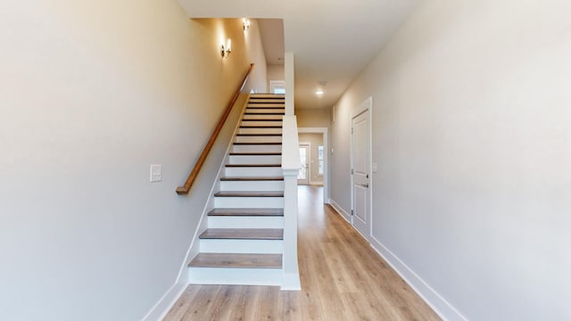 stairway featuring wood finished floors and baseboards