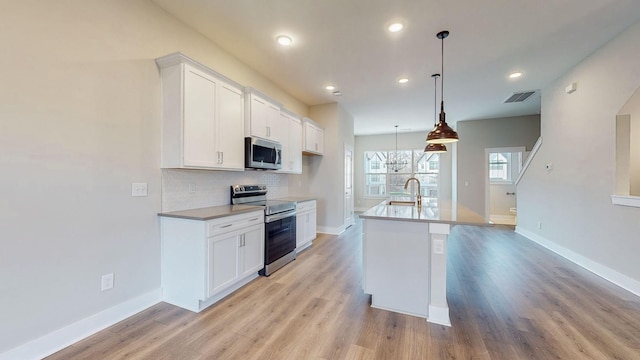 kitchen featuring stainless steel appliances, visible vents, decorative backsplash, and white cabinetry