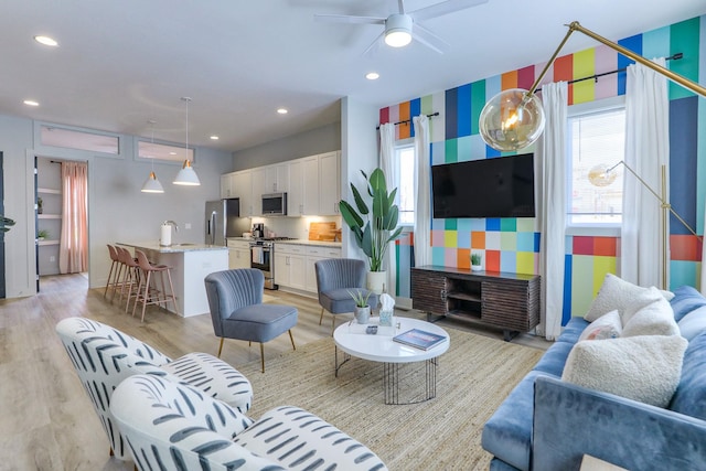 living room with a ceiling fan, recessed lighting, and light wood-style floors