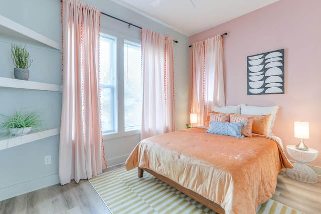 bedroom with baseboards and wood finished floors