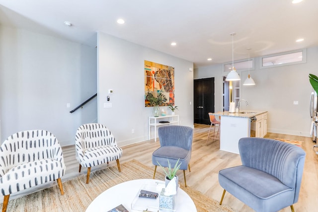 living room featuring recessed lighting, light wood-style floors, and baseboards