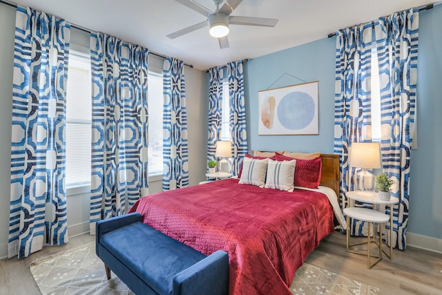 bedroom featuring wood finished floors, baseboards, and ceiling fan