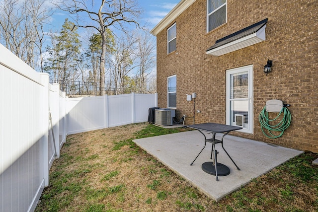 view of yard featuring a fenced backyard, central AC unit, and a patio