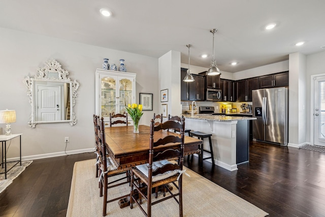 dining space featuring dark wood finished floors, recessed lighting, and baseboards