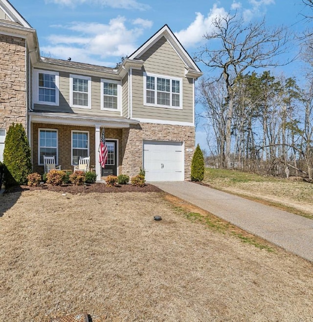 view of front facade with stone siding, concrete driveway, and a garage