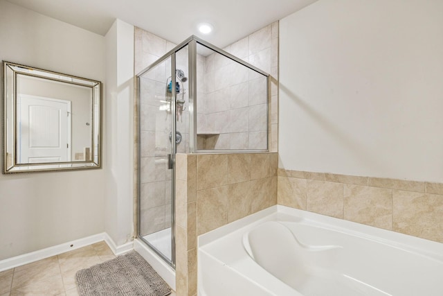 bathroom with a garden tub, baseboards, a stall shower, and tile patterned floors