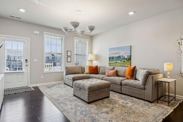 living area with a notable chandelier, visible vents, baseboards, and dark wood-style flooring