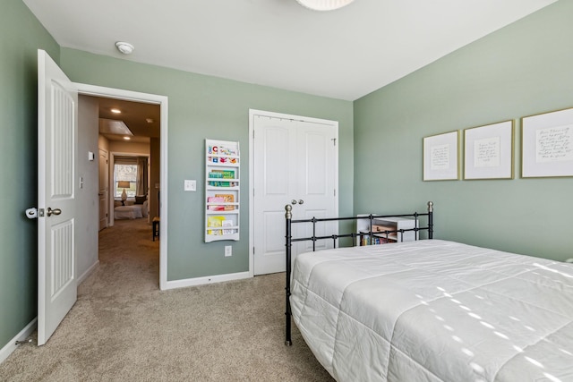 carpeted bedroom with baseboards and a closet