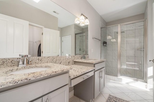 full bathroom with vanity, a spacious closet, visible vents, and a stall shower