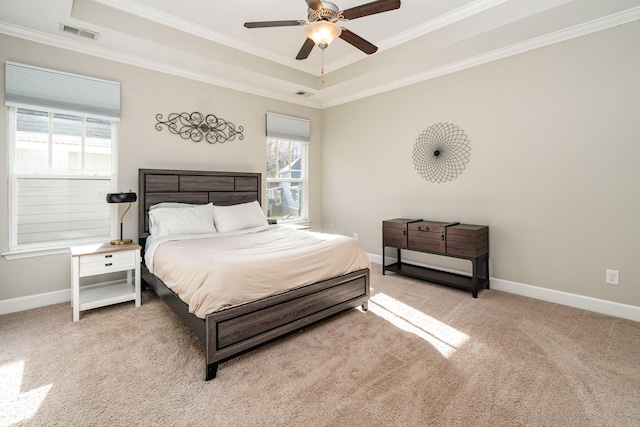 carpeted bedroom featuring visible vents, a raised ceiling, baseboards, and ornamental molding