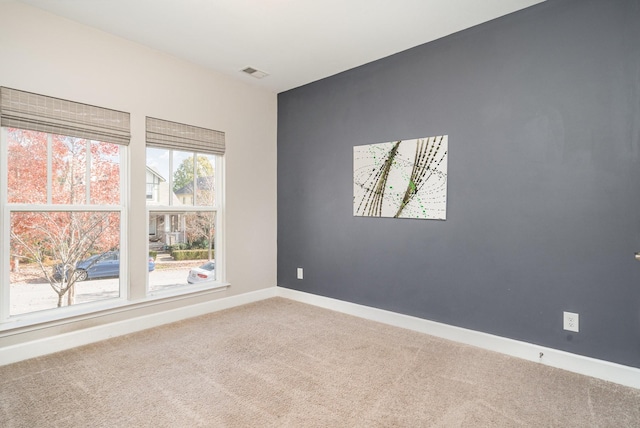 unfurnished room featuring visible vents, baseboards, and carpet