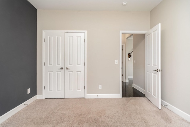 unfurnished bedroom featuring a closet, baseboards, and carpet flooring