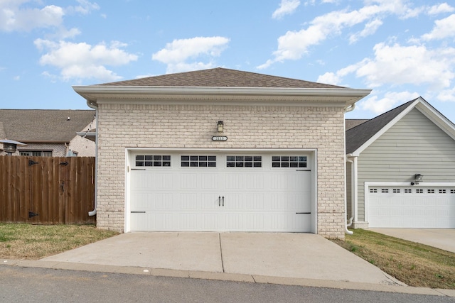 garage featuring fence and driveway