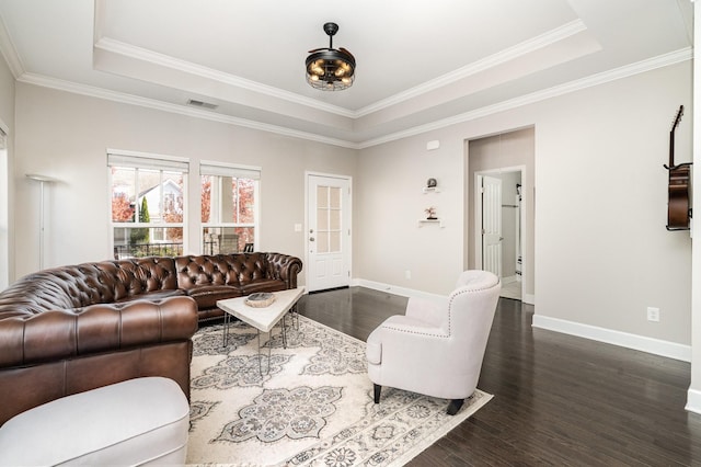 living area with a tray ceiling, baseboards, and dark wood-type flooring