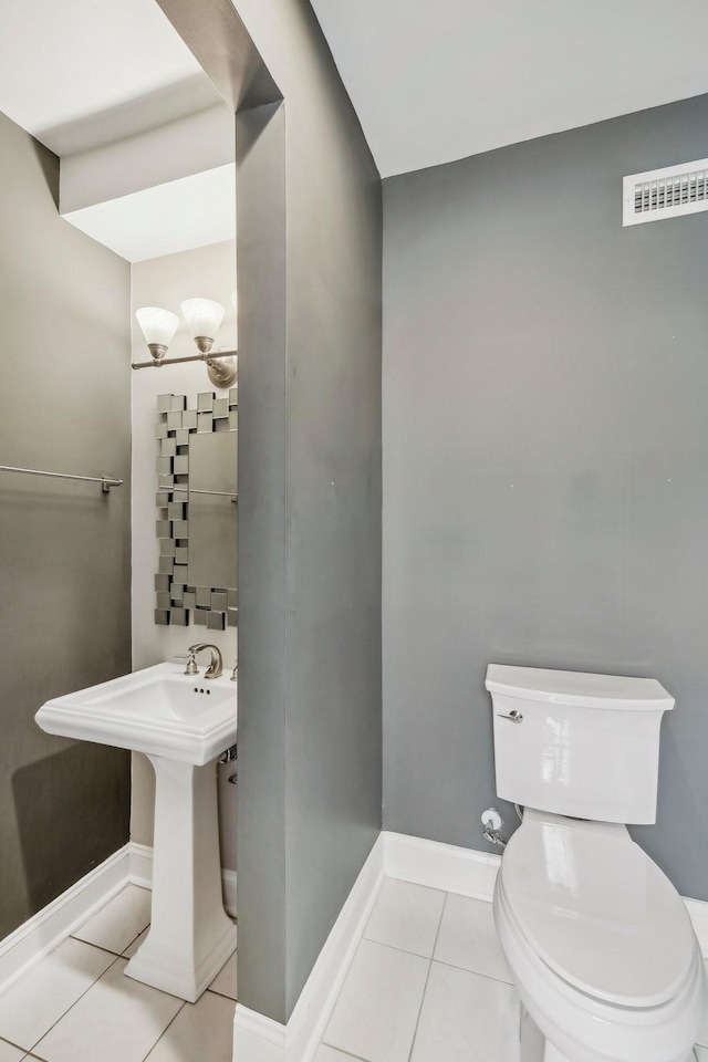 bathroom featuring baseboards, visible vents, a sink, tile patterned floors, and toilet