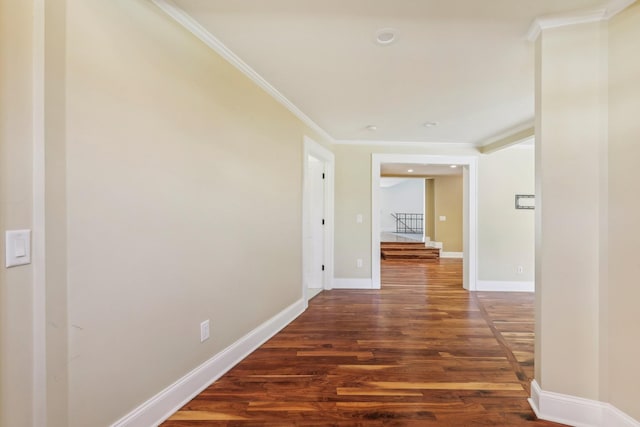 hall with wood finished floors, baseboards, and ornamental molding