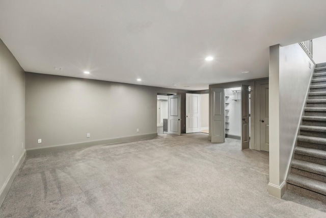 basement featuring stairway, recessed lighting, baseboards, and light carpet