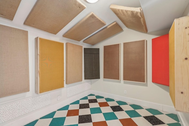 additional living space featuring tile patterned floors, baseboards, and lofted ceiling